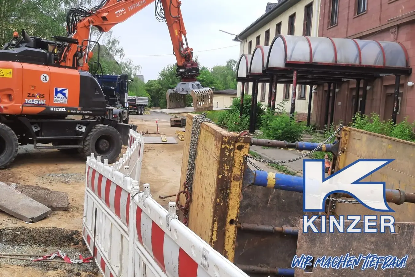 Mobilbagger an einer Kanalbaustelle, unten rechts Wasserzeichen mit Kinzer-Logo und Claim