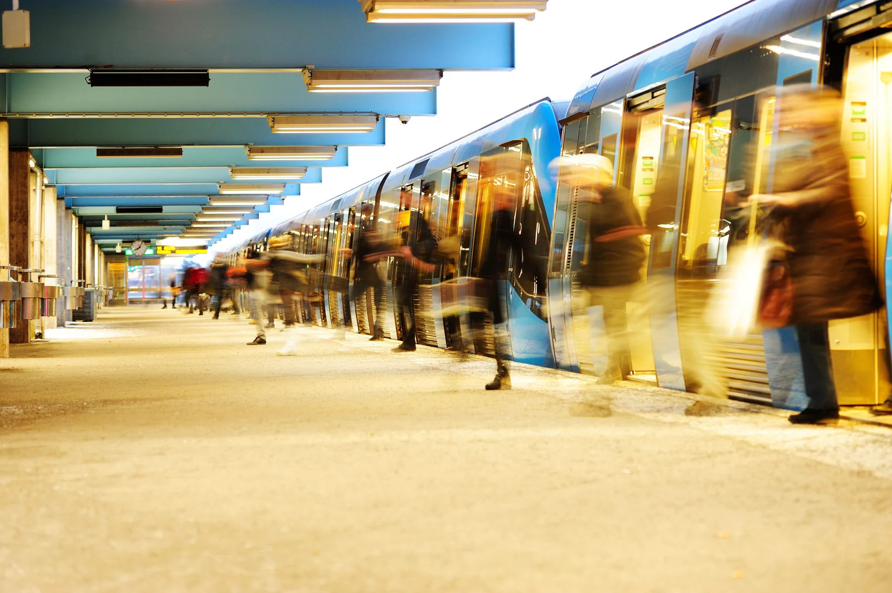 Bahnsteig mit einfahrendem Zug und Fahrgästen