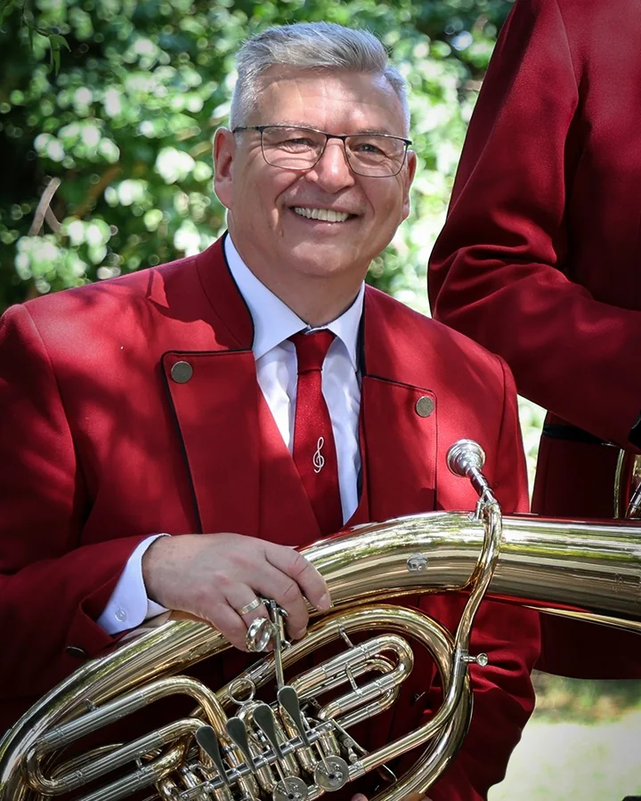 Musikerporträt mit Tenorhorn in der roten Vereinsjacke